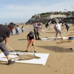 people drawing in the sand