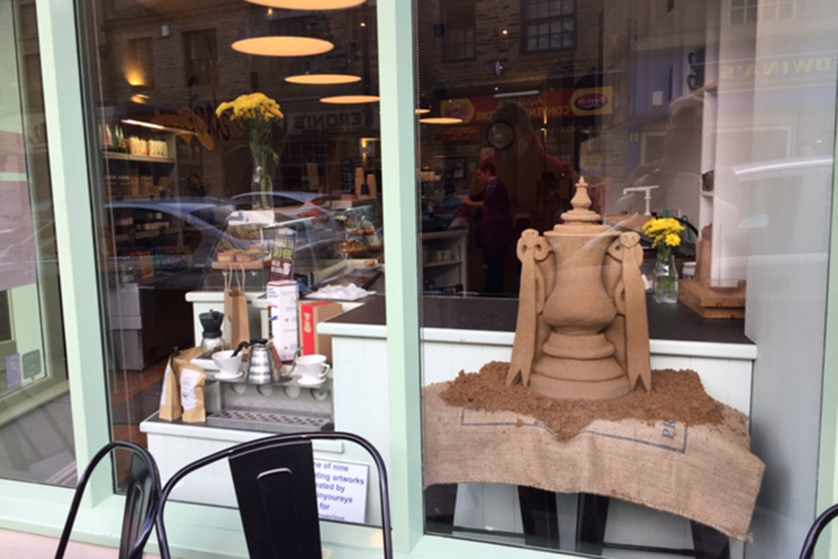 The FA cup sand sculpture sitting in the window of Folks Cafe for the Bantums fans to enjoy
