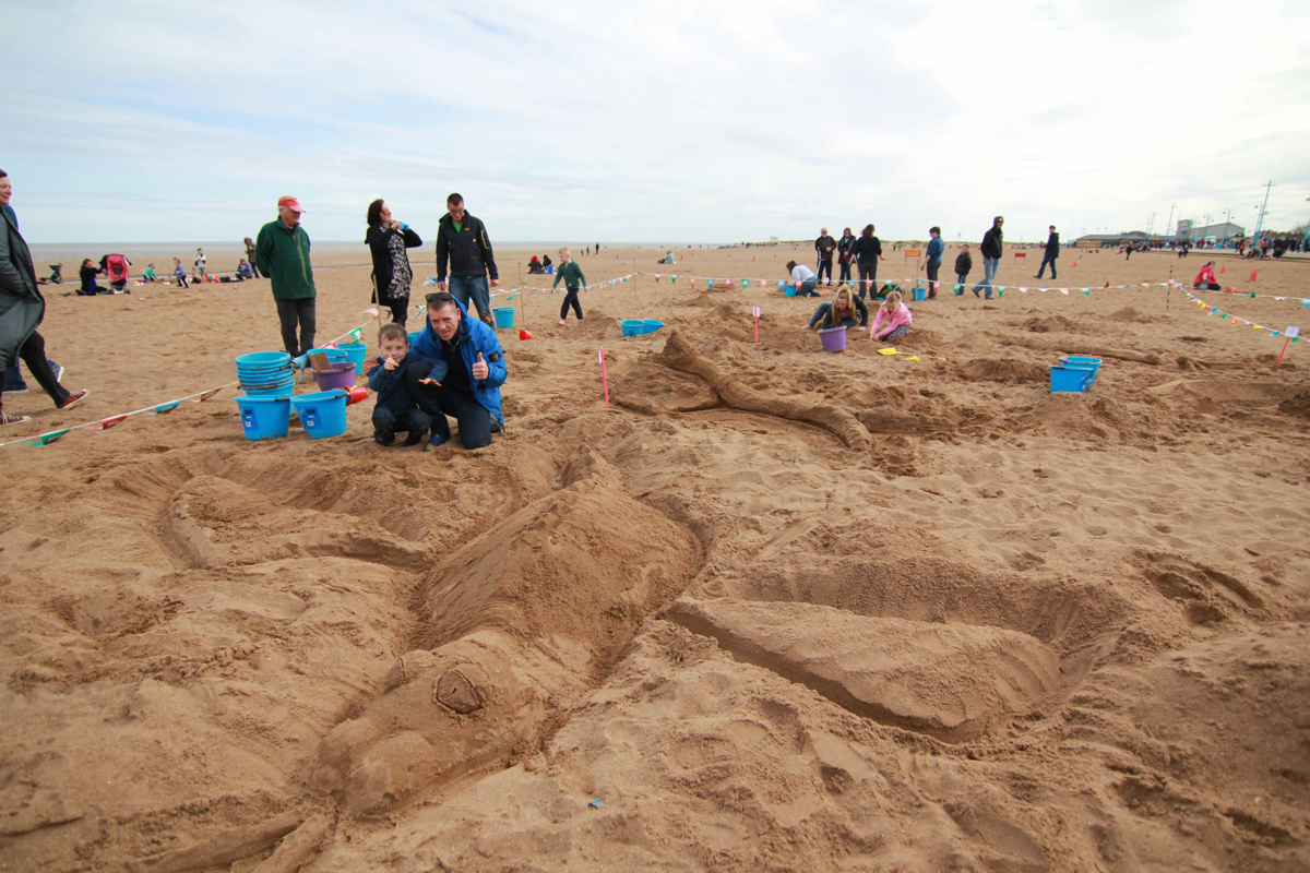 Sand sculpture competition winners with their dragon